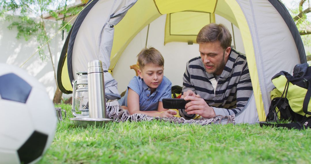 Father and Son Bonding in Tent with Smartphone - Free Images, Stock Photos and Pictures on Pikwizard.com