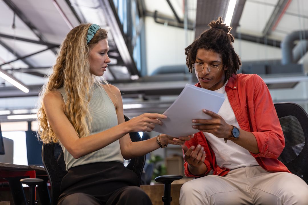 Diverse Coworkers Reviewing Documents in Open-Plan Office