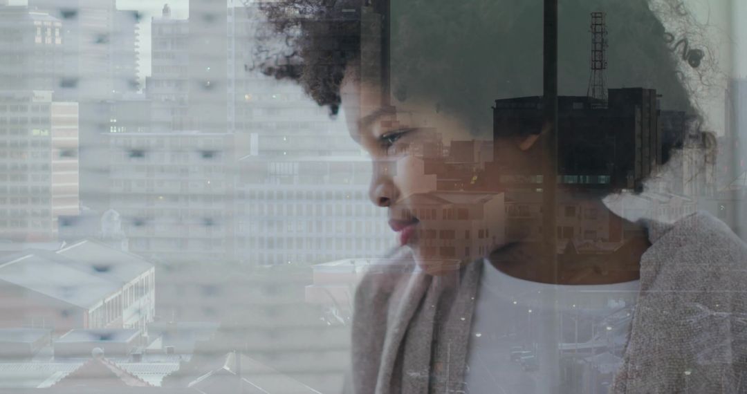 Gazing boy reflecting urban skyline through window, contemplative home portrait