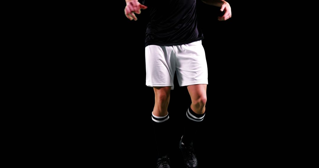 Soccer Player Jumping Isolated on Black Background - Free Images, Stock Photos and Pictures on Pikwizard.com