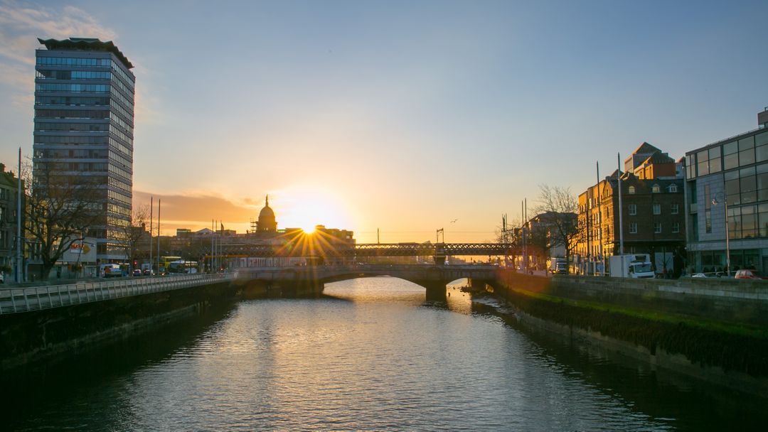 Sunset Over Calm River with City Bridge and Buildings - Free Images, Stock Photos and Pictures on Pikwizard.com