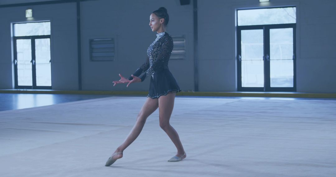 Graceful Rhythm Gymnast Performing Exercise in Gymnasium