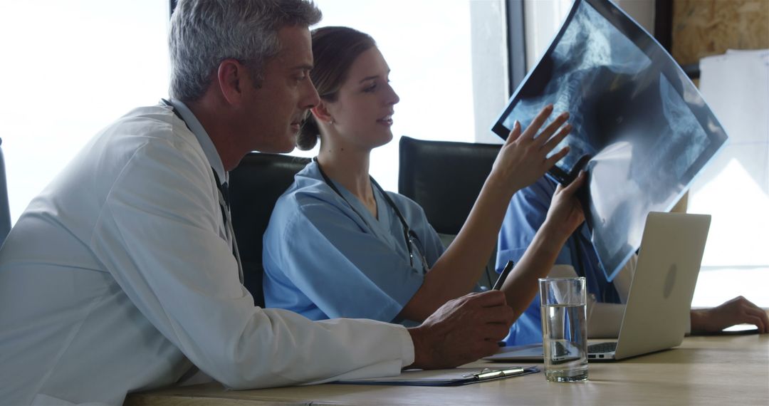 Doctors Analyzing X-Ray Film in Hospital Room - Free Images, Stock Photos and Pictures on Pikwizard.com