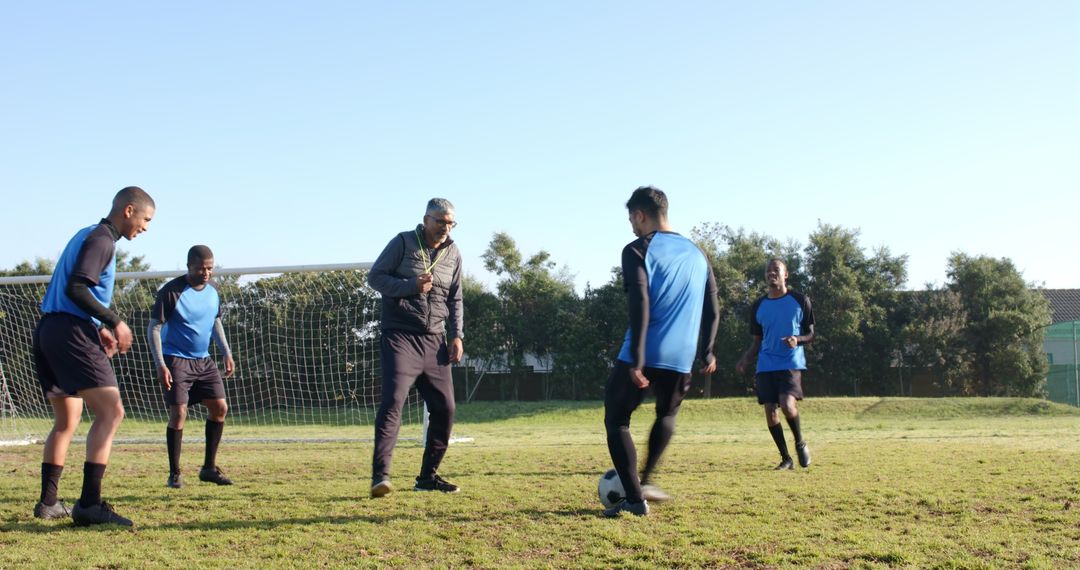 Diverse Soccer Team Training on Field with Coach