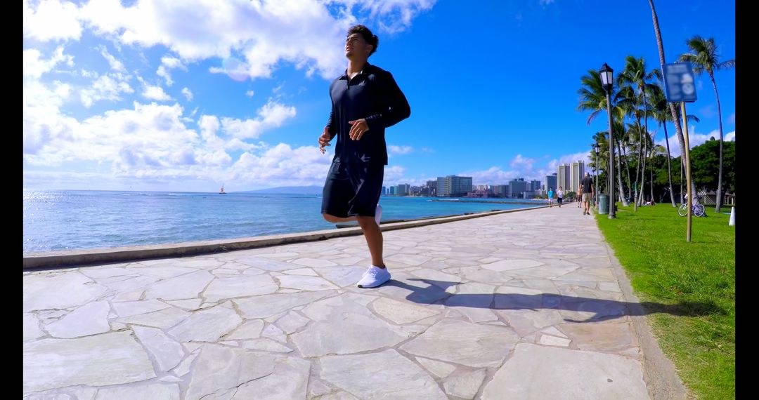 Young Man Jogging on Beachfront Pathway in Urban Coastal City - Free Images, Stock Photos and Pictures on Pikwizard.com