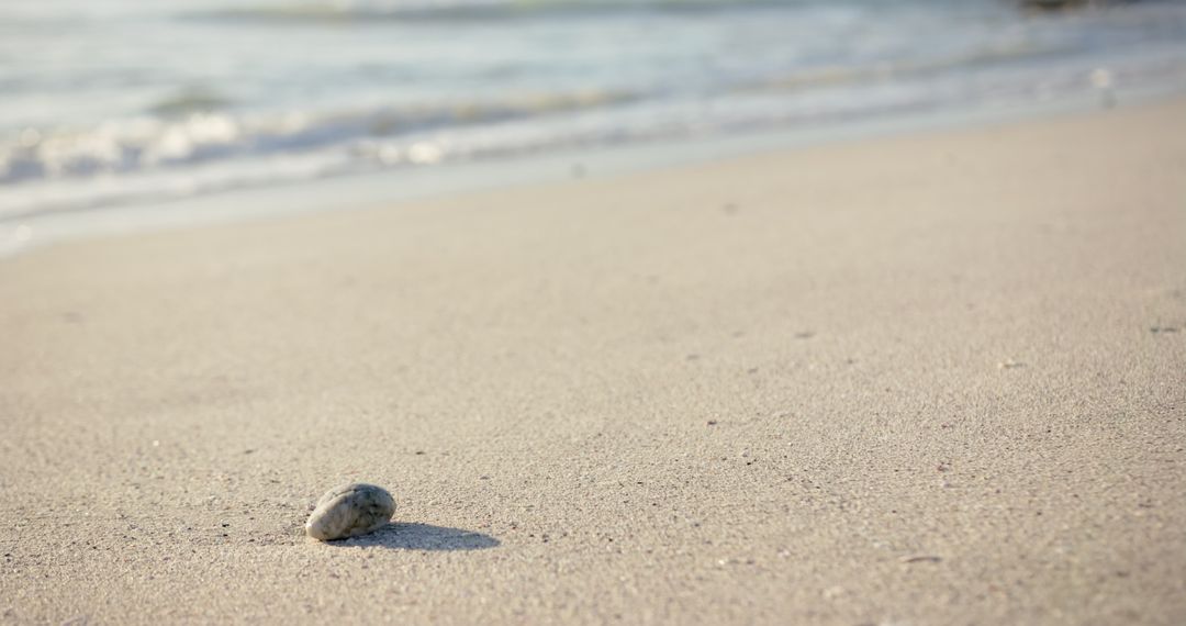 Serene Beach with Single Pebble and Gentle Waves