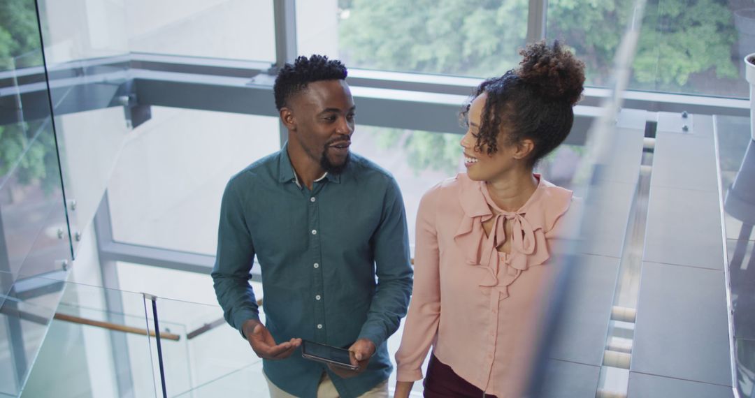 Diverse Colleagues Discussing Ideas While Walking Down Office Staircase