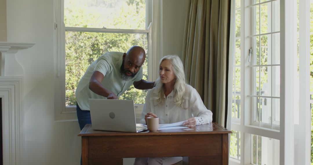 Man Assisting Woman with Laptop at Home, Collaboration in Technology