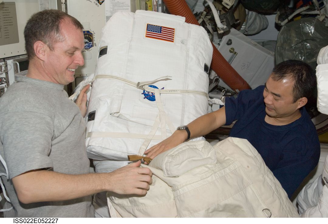 Creamer and Noguchi works on EMU in the A/L during Expedition 22 - Free Images, Stock Photos and Pictures on Pikwizard.com