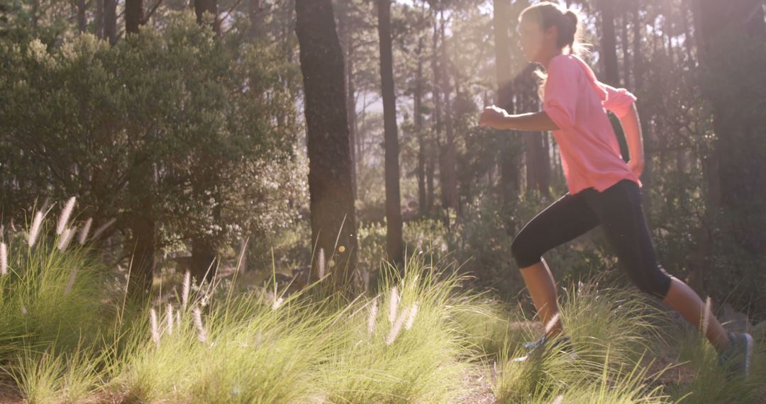 Woman jogging through forest on a sunny day - Free Images, Stock Photos and Pictures on Pikwizard.com