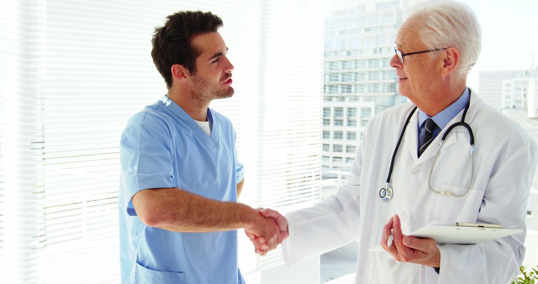 Young Nurse Shaking Hands with Senior Doctor in Bright Medical Office - Free Images, Stock Photos and Pictures on Pikwizard.com