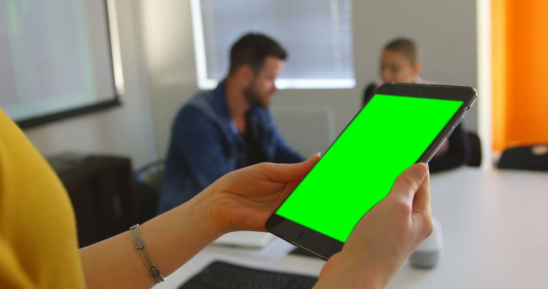 Person Holding Tablet with Green Screen in Office Meeting - Free Images, Stock Photos and Pictures on Pikwizard.com