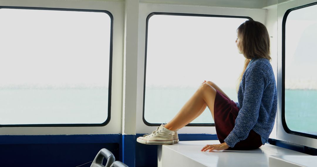 Young Woman Enjoying Scenic Sea View Through Boat Window - Free Images, Stock Photos and Pictures on Pikwizard.com