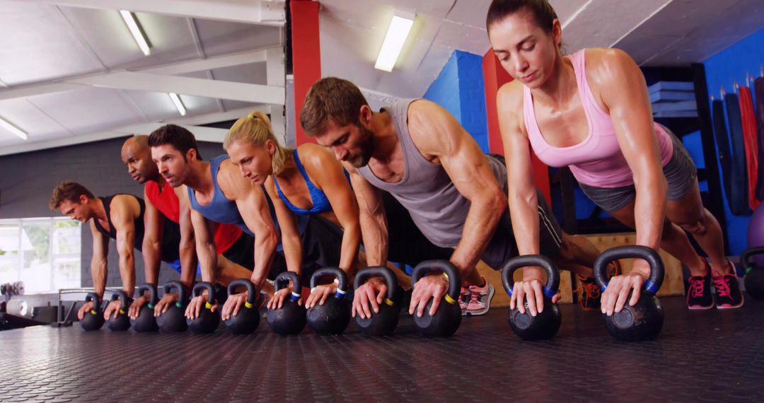 Group Holding Kettlebell Plank Building Core Strength and Teamwork in Gym