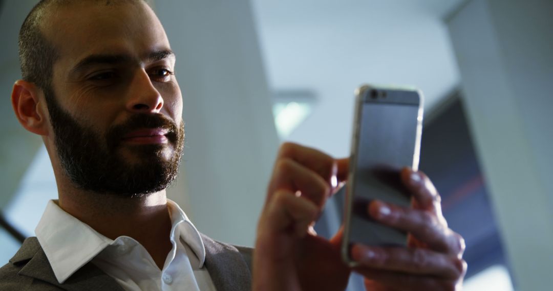 Confident Businessman Using Smartphone in Office - Free Images, Stock Photos and Pictures on Pikwizard.com