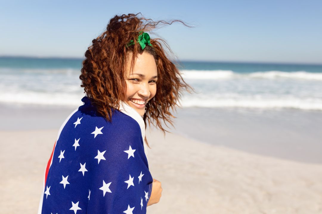 Biracial woman with curly brown hair is smiling at beach - Free Images, Stock Photos and Pictures on Pikwizard.com