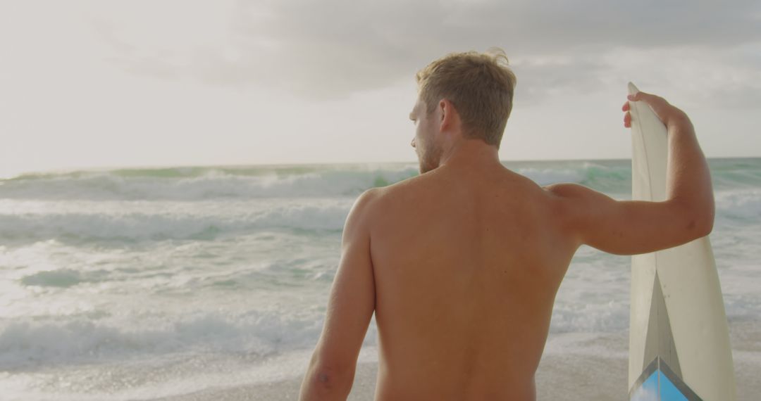Surfer Watching Waves Beachside During Sunset