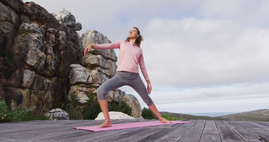 Woman Practicing Yoga Outdoors on Wooden Deck by Rocky Cliff - Free Images, Stock Photos and Pictures on Pikwizard.com