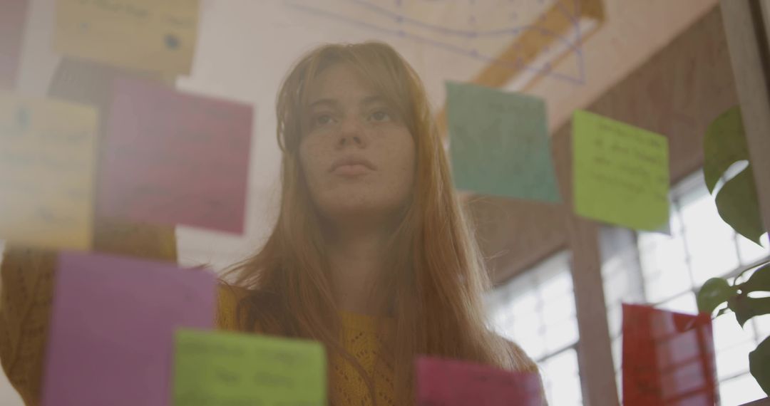 Creative Woman Analyzing Sticky Notes at Workplace