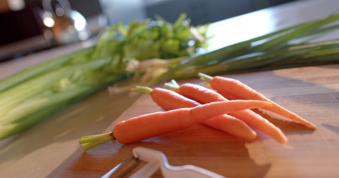 Fresh Carrots with Vegetable Peeler on Wooden Cutting Board in Modern Kitchen - Free Images, Stock Photos and Pictures on Pikwizard.com