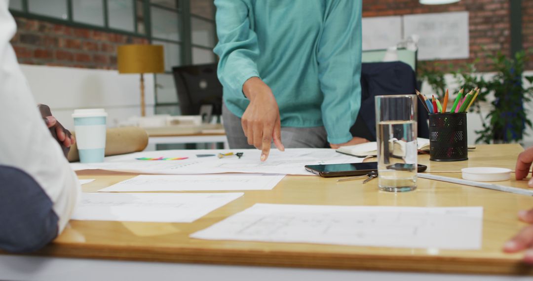 Creative Team Analyzing Blueprints in Office Meeting