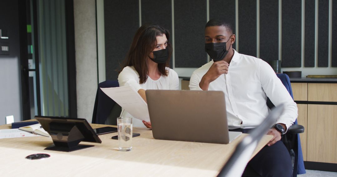 Colleagues Collaborating with Masks in Modern Office