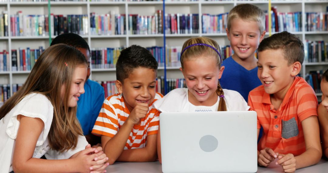 Smiling Children Learning Together on Laptop in Library - Free Images, Stock Photos and Pictures on Pikwizard.com