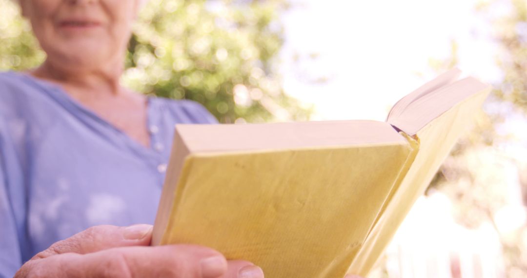 Senior Woman Reading Yellow Book Outdoors - Free Images, Stock Photos and Pictures on Pikwizard.com