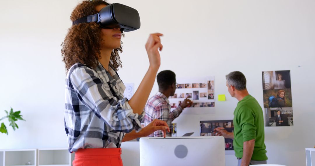 Intern Engaged in Virtual Reality While Colleagues Collaborate
