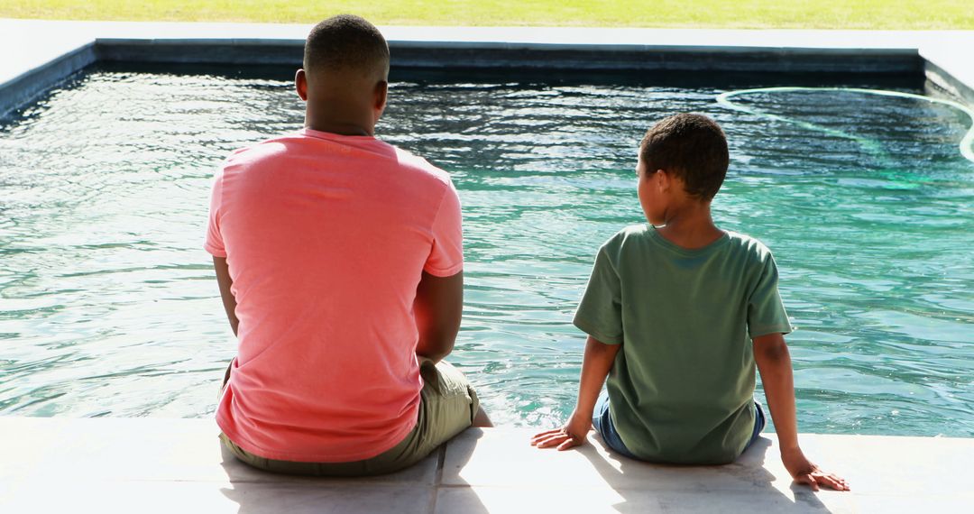 Father and Son Sitting by Pool Enjoying Summer Day - Free Images, Stock Photos and Pictures on Pikwizard.com