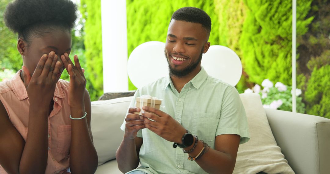 Couple Smiling and Exchanging Gifts on Relaxing Patio
