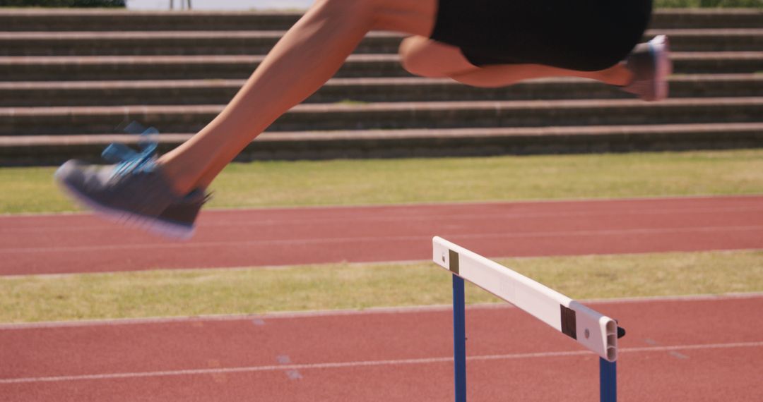 Athlete Jumping Over Hurdle on Track - Free Images, Stock Photos and Pictures on Pikwizard.com