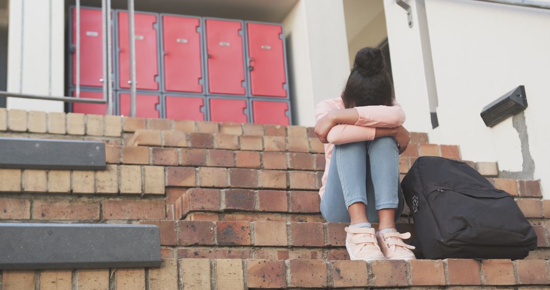 Sad Teen Girl Sitting Alone on School Steps with Head Down