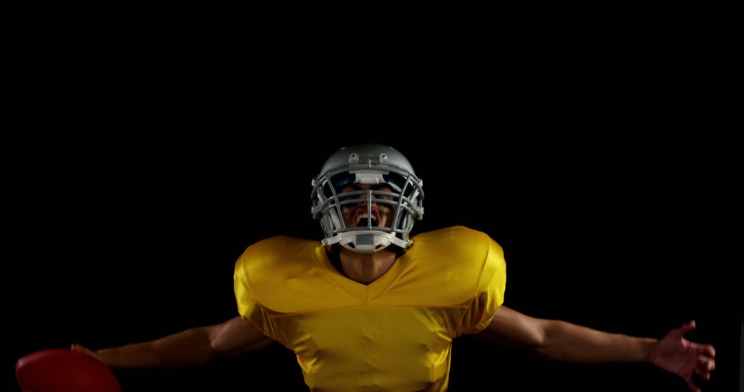 American football player celebrating with arms outstretched against black background - Free Images, Stock Photos and Pictures on Pikwizard.com