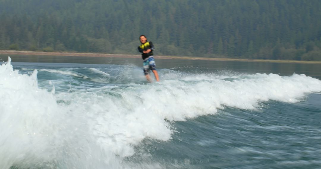 Person Wakeboarding on Lake with Forested Mountain Background - Free Images, Stock Photos and Pictures on Pikwizard.com