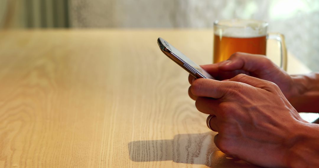 Person Using Smartphone with Drink on Table in Cafe - Free Images, Stock Photos and Pictures on Pikwizard.com