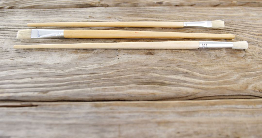 Three Paintbrushes on Rustic Wooden Background - Free Images, Stock Photos and Pictures on Pikwizard.com