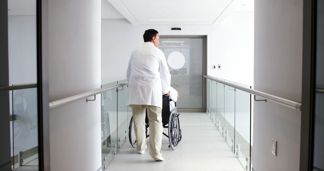 Doctor Pushing Patient in Wheelchair Down Hospital Corridor - Free Images, Stock Photos and Pictures on Pikwizard.com