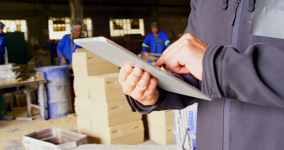 Worker Using Tablet in Warehouse with Boxes in Background - Free Images, Stock Photos and Pictures on Pikwizard.com