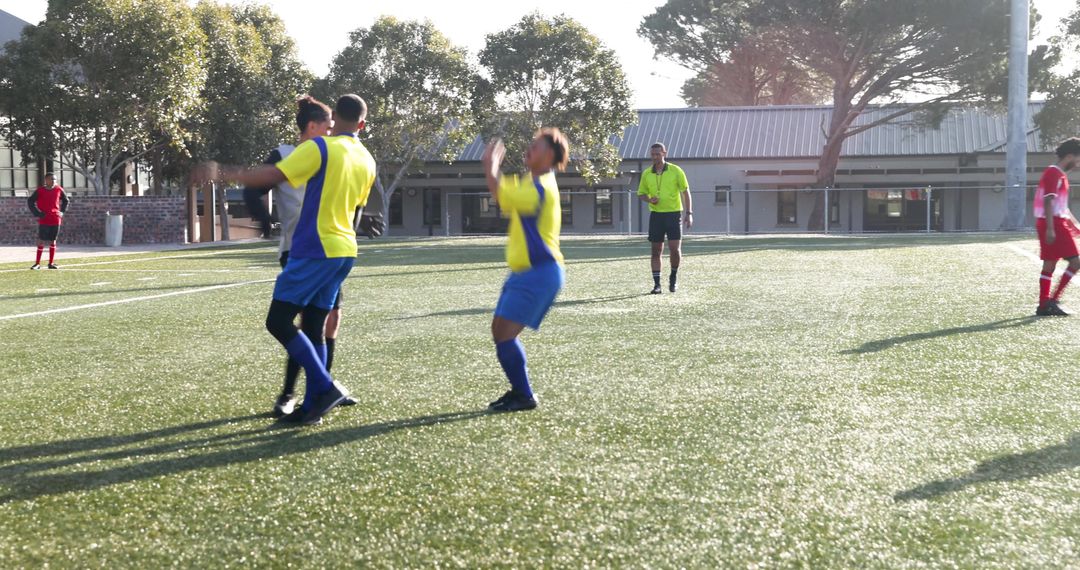 Soccer Players Celebrating Victory on Field in Daylight
