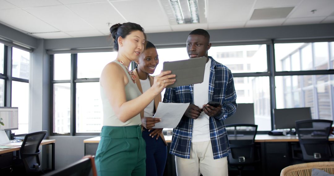Diverse Collegial Team Collaborating on Innovative Project in Modern Office