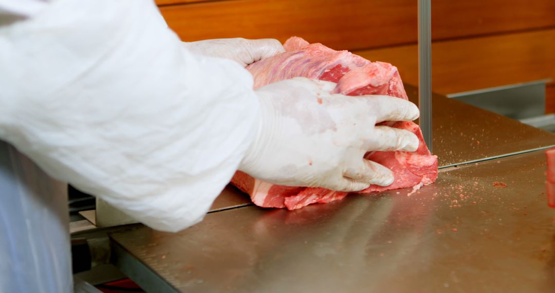 Butcher Slicing Large Piece of Meat on Metal Table - Free Images, Stock Photos and Pictures on Pikwizard.com