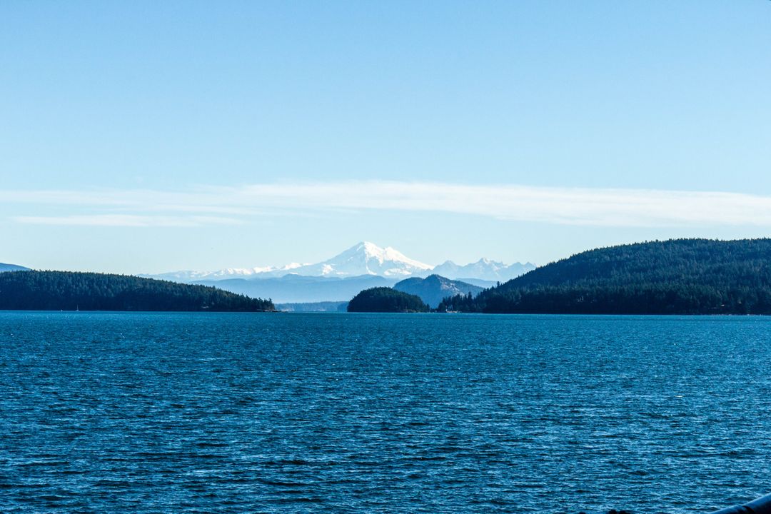Snow-capped Mountain Behind Serene Lake and Forested Islands - Free Images, Stock Photos and Pictures on Pikwizard.com