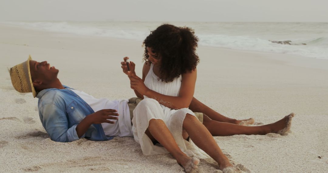 Couple Enjoying Relaxing Beach Day with Smartphone