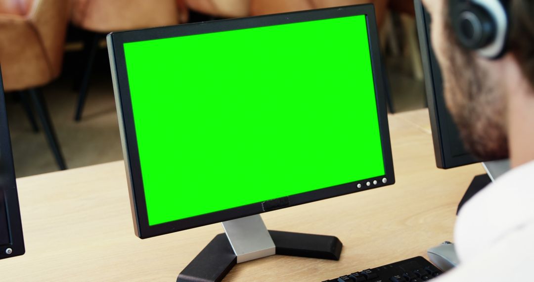 Professional Working on Large Monitor with Green Screen Display - Free Images, Stock Photos and Pictures on Pikwizard.com