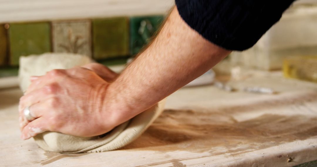 Craftsman Sculpting Clay with Hands in Pottery Workshop
