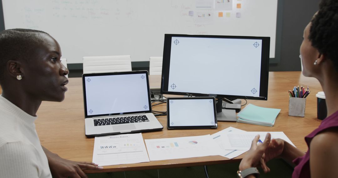 Colleagues Discussing Architectural Blueprints in Modern Office