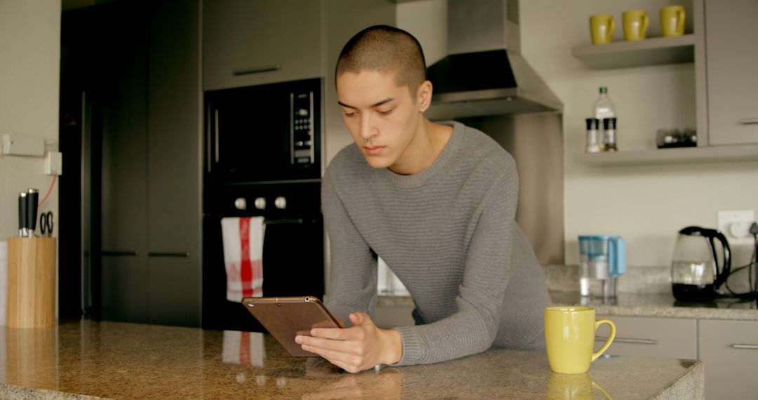 Young Man Using Digital Tablet in Modern Kitchen - Free Images, Stock Photos and Pictures on Pikwizard.com