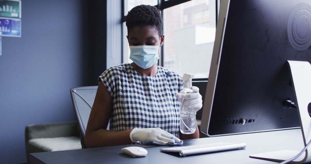 Office Worker Cleaning Desk with Sanitizer During Pandemic - Free Images, Stock Photos and Pictures on Pikwizard.com