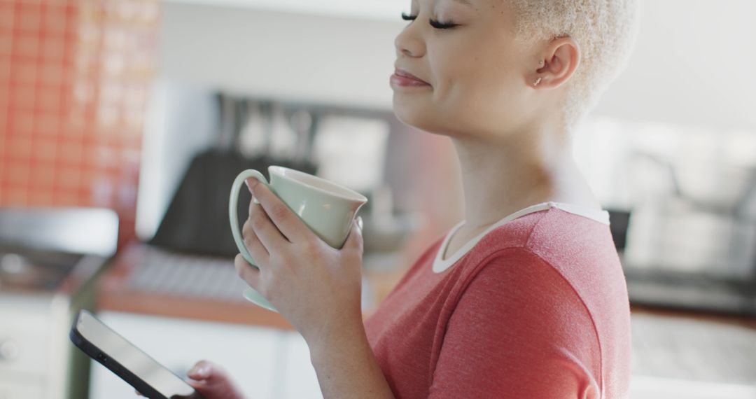 Smiling Woman Relaxing with Coffee and Tablet in Kitchen - Free Images, Stock Photos and Pictures on Pikwizard.com